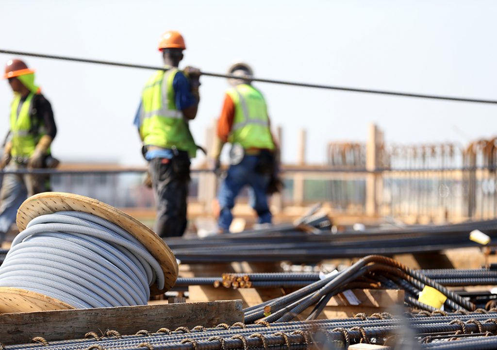 blurry view of people on a construction site surrounded by metal bars and wires