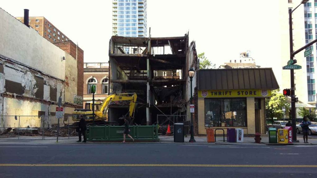 During demolition, where you can see the eventual free-standing brick wall up against the Salvation Army building