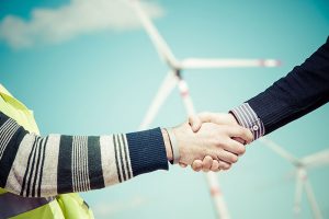 Environmental Consultant working with a customer, Engineers giving Handshake in a Wind Turbine Power Station Italy