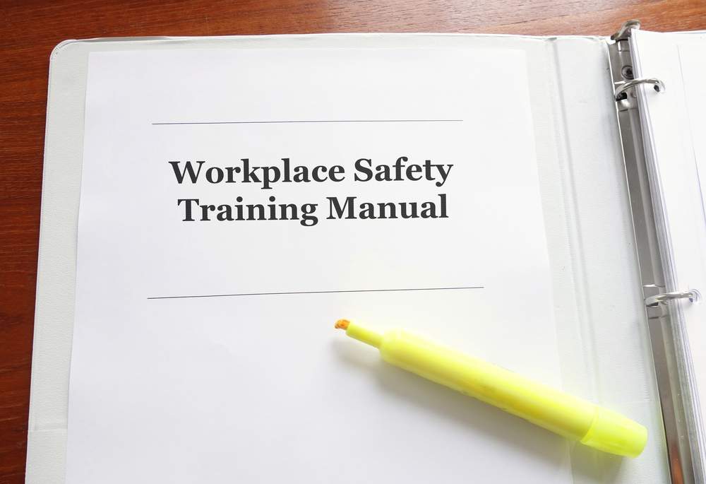 Employee Workplace Safety Training Manual on a desk with highlighter