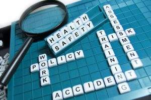 health safety and other risk management phrases on scrabble tiles on a board