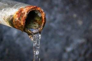 water pouring from pipe with lead contamination