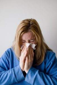 woman sneezing with aggravated allergies due to mold