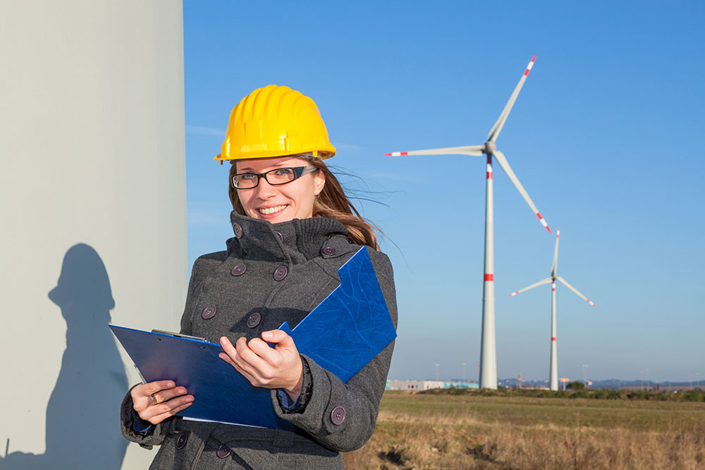 woman at a wind turbine for environmental consulting